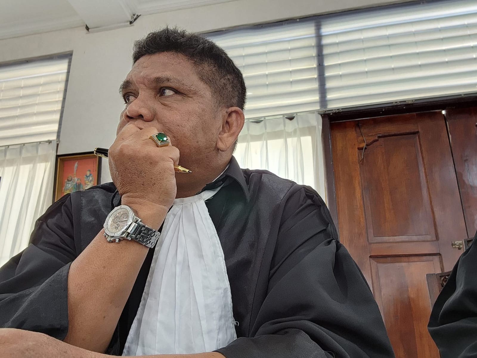 Ekspresi mendalam Raymond Simamora, S.H., M.H. yang tampak sedang menyimak jalannya persidangan dengan saksama dalam balutan toga advokat.
